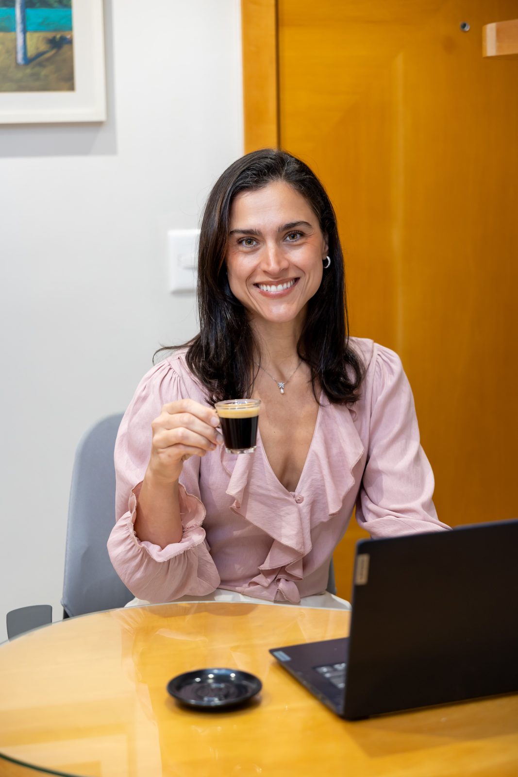 Dra. Alessandra Cohen sorrindo, com uma xícara de café
